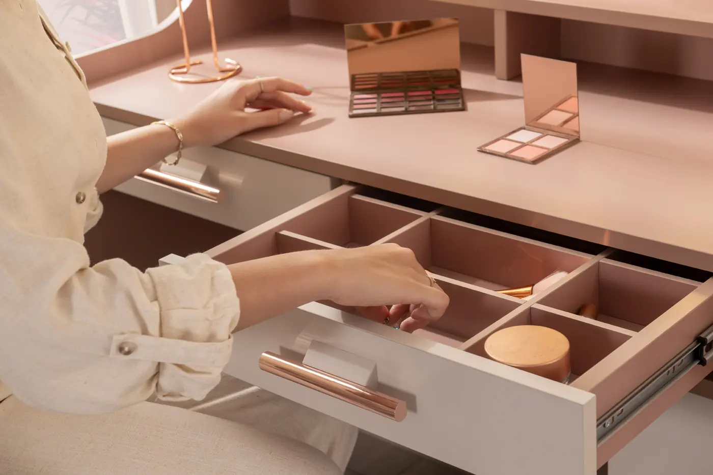 Hand opening a vanity drawer with fitted organiser
