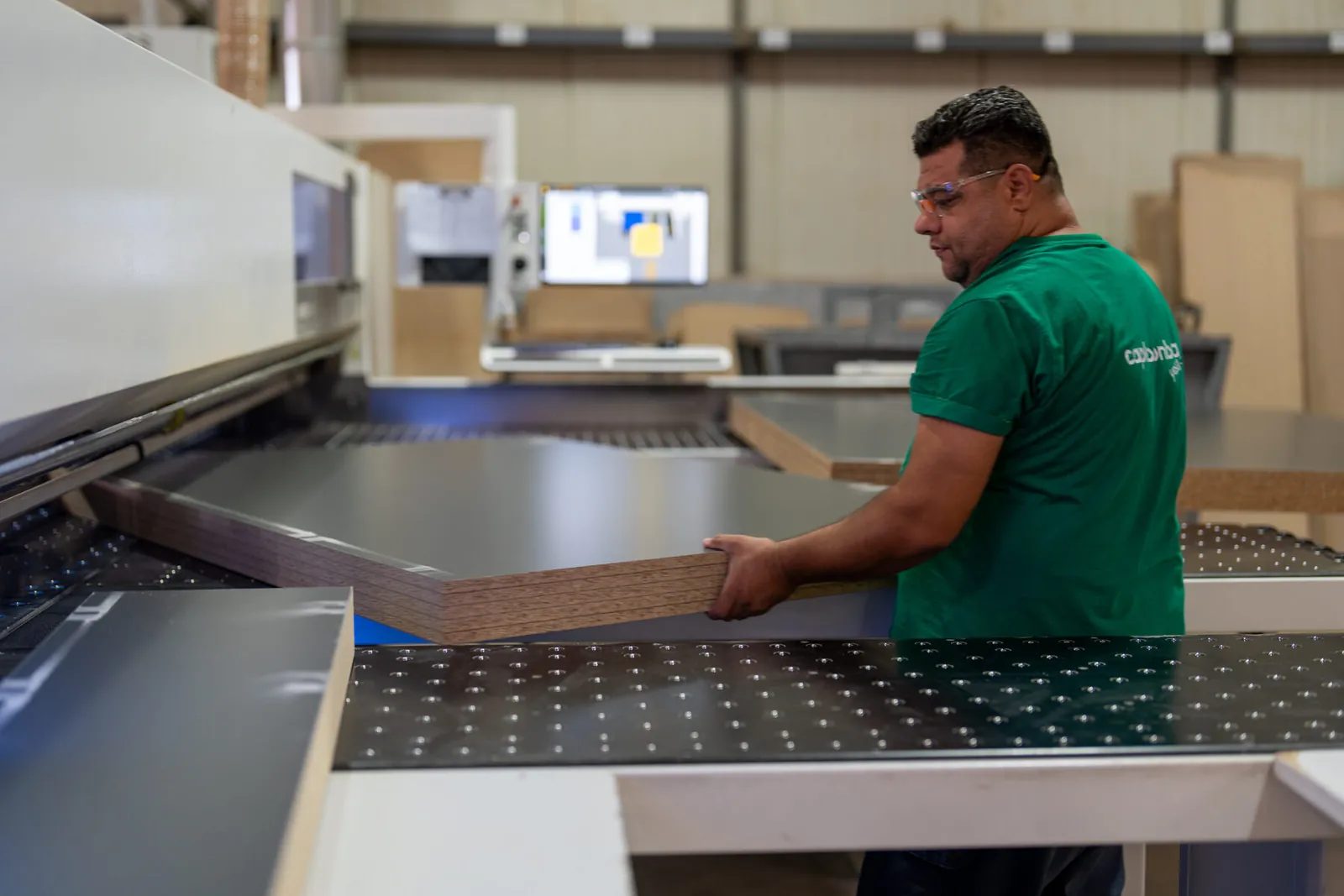 A board being loaded onto the beam saw