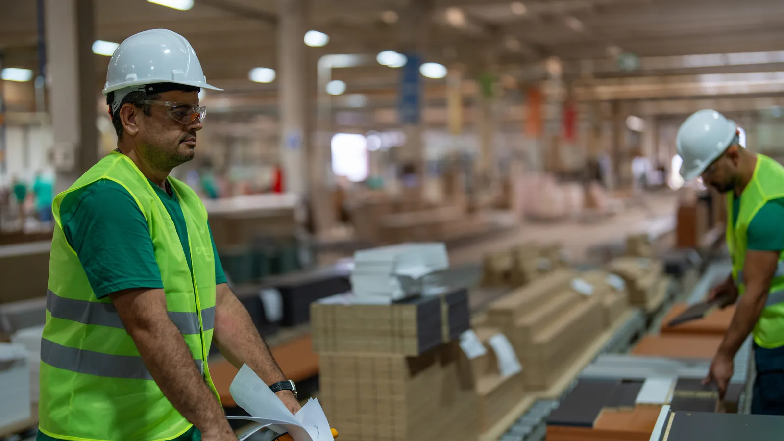 Two operators handling parts and flat cartons on the line