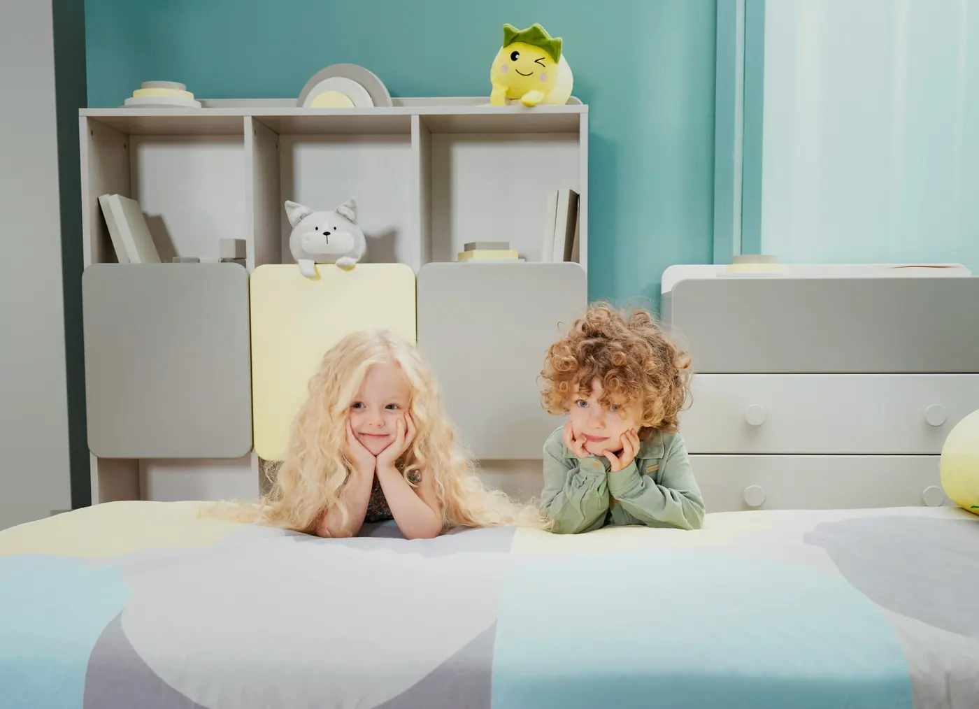 Two children lying on a Minia bed