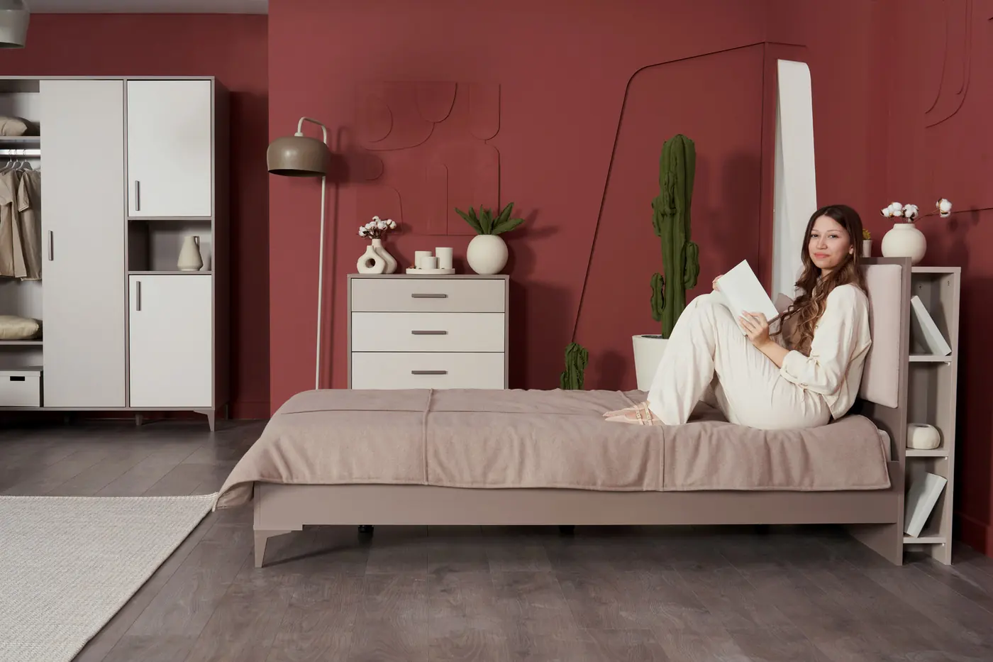 Woman reading on a Riga bed with bookshelf headboard